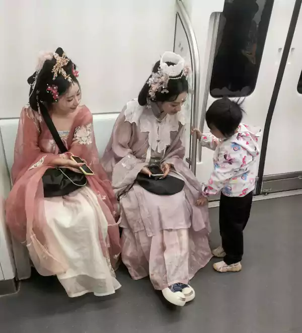 两位穿汉服的美女吸引众人目光 她们身段苗条 妆容艳丽 服装华美